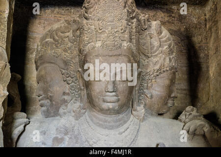 Die 3 Gesichter von Shiva auf der Innenseite der Grotte auf der Insel Elephanta, geschnitzt aus Felsen Stockfoto