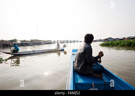 Dorfbewohner steuern ihre Boote durch die schwimmenden Dorf von Prek Toal auf See Tonle Sap. Stockfoto