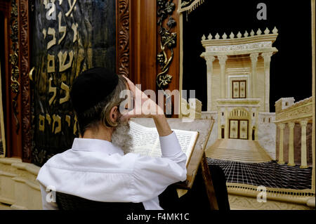 Ein jüdischer Verehrer betet neben einem Schrank der Torah Ark, in dem die jüdischen Torah-Schriftrollen mit einer Figur des biblisch-jüdischen Tempels im Männerbereich des Wilson's Arch auf dem Gelände der Westmauer in der Altstadt zu sehen sind. Ost-Jerusalem, Israel Stockfoto