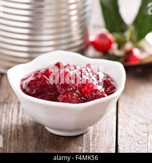 Cranberry-Sauce im Schälchen mit metallischen Gefäß im Hintergrund Stockfoto