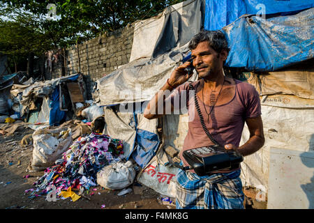 Ein Mann, in dharavi Armenviertel arbeiten, ist das zweite größte Slumgebiet in Asien, ist mit einem -Telefon Stockfoto