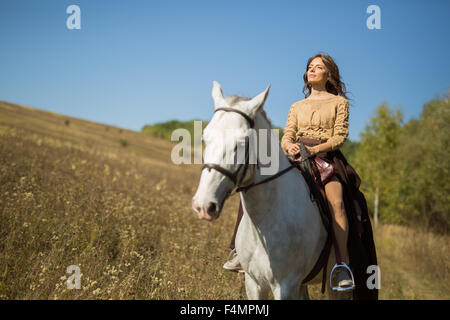 Schöne Mädchen auf einem weißen Pferd Stockfoto
