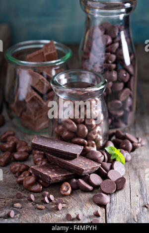 Schokoladenstücke, Chips, Süßigkeiten und Bars in Gläsern Stockfoto