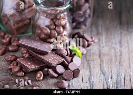 Schokoladenstücke, Chips, Süßigkeiten und Bars in Gläsern Stockfoto