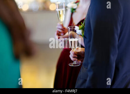 Hochzeitsgäste sprechen und halten Champagner Stockfoto