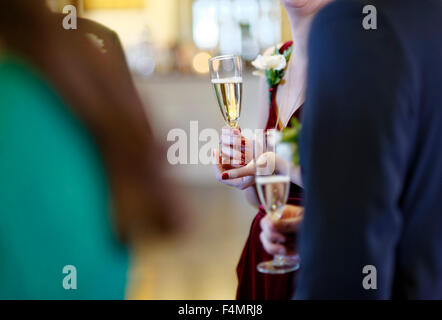 Hochzeitsgäste sprechen und halten Champagner Stockfoto