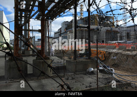 Leute arbeiten auf der Baustelle unteranderem zwischen den zerstörten Reaktor Nr. 4 und den neuen sicheren Einschluss. Ukraine Stockfoto