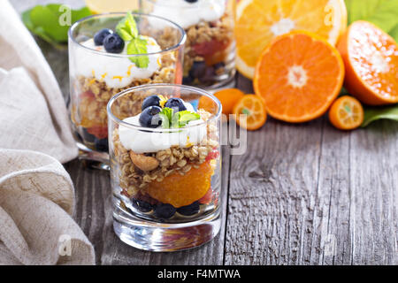 Müsli-Frühstück-Parfait mit Zitrus-Kompott und Heidelbeeren Stockfoto