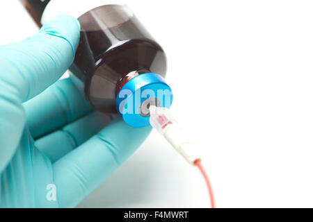 Techniker hält Blut Kulturflasche mit Transfer Schläuche. Stockfoto