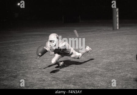 Varsity Football-Spieler taucht, um einen Pass in die Endzone zu fangen. Monache High School Marodeure Stockfoto