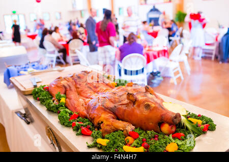 Ganze Schwein bei einer Hochzeit mit einem Apfel im Maul auf einem Tisch. Stockfoto