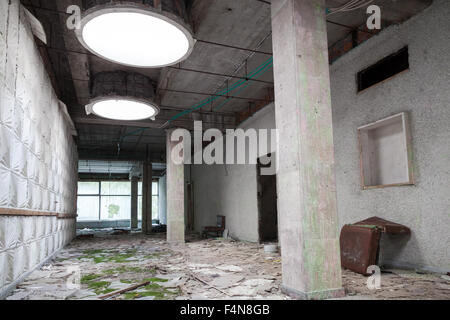 Verlassenes Industriegebäude Interieur. Grünes Moos wachsen unter leichten Rundlöchern in Decke Stockfoto