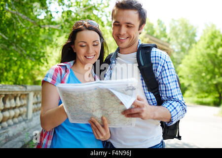 Junge Reisende, die auf Karte in natürlicher Umgebung Stockfoto