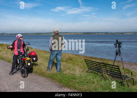 Radfahrer auf dem Hadrian Cycleway NCN 72] Haltestellen für einen Plausch mit einer lokalen Vogelbeobachter von Solway Firth Stockfoto