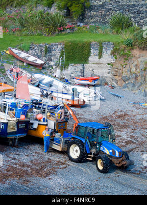 New Holland Traktor auf Cadgwith Strand, Halbinsel Lizard, Cornwall, England, Vereinigtes Königreich Stockfoto