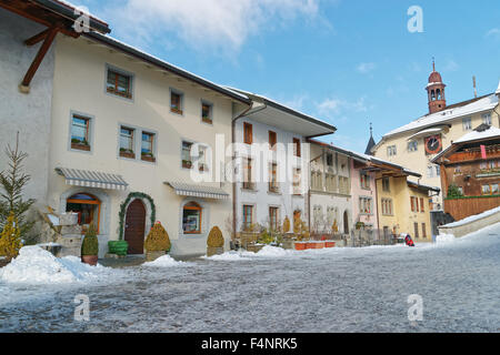 Blick auf die Hauptstraße in der Schweizer Stadt Gruyères (Schweiz) mit Schnee bedeckt. Gruyère ist ein wichtiges touristisches Ziel Stockfoto