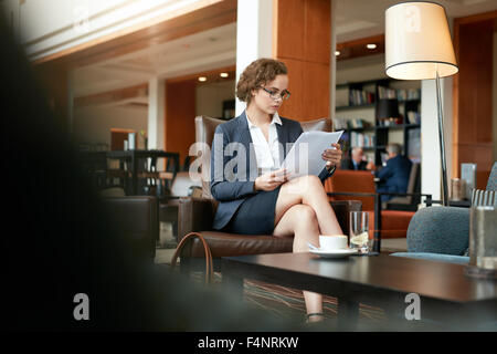 Schuss der junge Geschäftsmann sitzen im Café lesen von Dokumenten. Kaukasische Geschäftsfrau durchläuft einige Papiere. Stockfoto