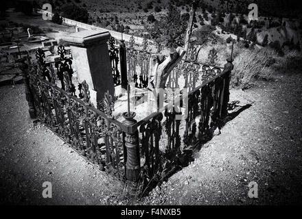 Grab in einem alten Friedhof, der zu den Elementen in schwarz / weiß Film Noir körnig wirkt sich für Halloween gemacht gelassen hat Stockfoto