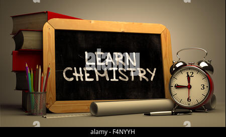 Lernen Sie handschriftlich auf Tafel Chemie. Motivierenden Zitat. Komposition mit Tafel und Stapel von Büchern, Wecker und S Stockfoto