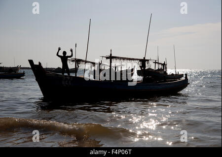 Silhouetten der birmanischen Fischer aus laden ihre Boote bei Sonnenuntergang am Ngapali Strand Myanmar Stockfoto