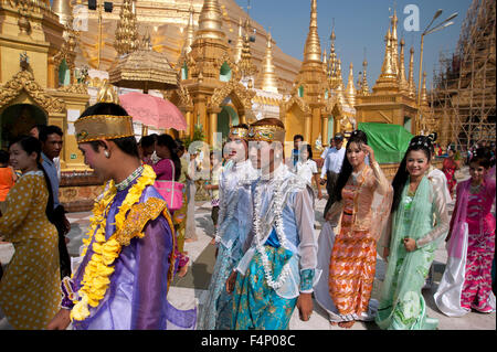 Burmesische Familien gekleidet in glanzvollen Zeremonie Kostüm Menge Marmor Gehwege von der Shwedagon-Pagode in Yangon, Myanmar Stockfoto