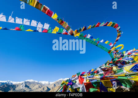 Bunte tibetean Gebetsfahnen sind vor blauem Himmel winken, die schneebedeckten Berge in der Ferne Stockfoto