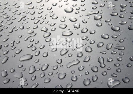 Regentropfen auf einer Silberoberfläche mit Sonne einen Lichteffekt hinzufügen Stockfoto