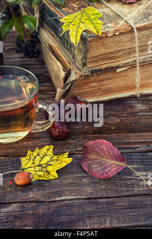 Tasse Kräutertee inmitten der Bündel Bücher der alten im Herbst Stil Stockfoto