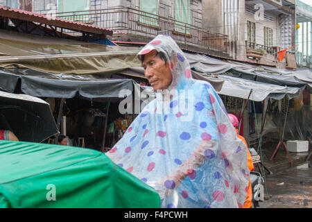 Hoi an eine alte Stadt Vietnam, Cyclo Rikscha Fahrer mit Regenschutz zu halten trocken während Gewitter, Vietnam Stockfoto