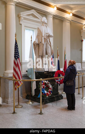 Ein Besucher mit Blick auf die Statue von Dr. Joseph Warren, angrenzend an das Bunker Hill Monument, Boston, Massachusetts, USA Stockfoto