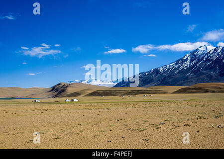 Karge Landschaft mit nomades Zelte und die schneebedeckten Berge im Bereich changtang Stockfoto