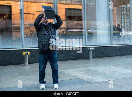 Senioren männlich fotografieren auf der 42nd Street in New York City mit einem tablet Stockfoto