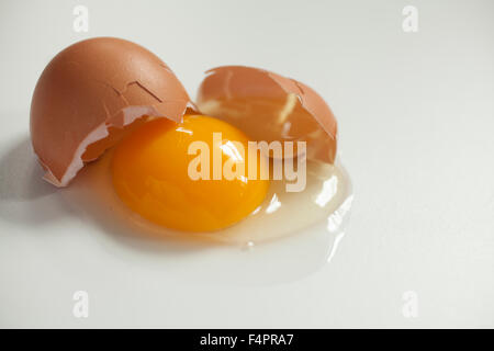 Rohes Ei braunes auf weißem Hintergrund gebrochen. Stockfoto