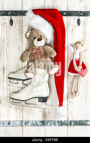 Rot-Weihnachtsmänner Hut, Teddybär, Engel und weiße Schlittschuhe. Vintage-Stil-Weihnachtsdekoration Stockfoto
