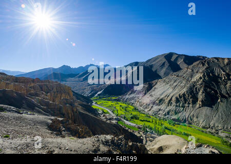 Karge Landschaft, grüne Wiesen und blauer Himmel im Dorf lamayuru, der moonlands in der Ferne Stockfoto