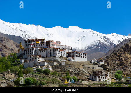 Die Gebäude von likir Gompa, ein Kloster auf einem Hügel in kargen Landschaft, schneebedeckte Berge in der Ferne Stockfoto