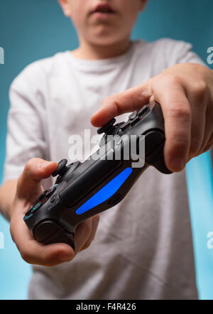 Ein Kind, das Spielen von Computerspielen mit PS4 Playstation 4 controller Stockfoto