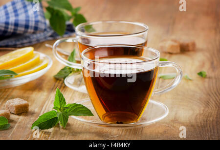 Tassen Tee mit Minze und Zitrone auf einem Holztisch. Selektiven Fokus Stockfoto