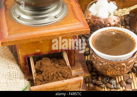 Kaffee in verschiedenen Formen rund um Oldtimer Kaffeemühle. Gemahlenen Kaffee in einer Schublade Stockfoto