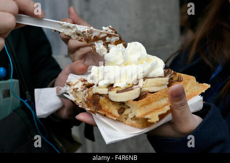 Touristen teilen Brüssel Freude – Gaufre oder Waffel mit Sahne und Früchten Stockfoto