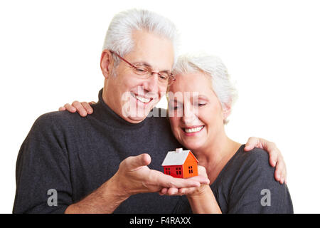 Zwei glückliche Senioren mit kleinen roten Haus Stockfoto