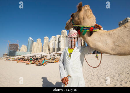 Touristischen Kamel und Besitzer am Strand im JBR Jumeirah Beach Residences im Marina District von Dubai Vereinigte Arabische Emirate Stockfoto