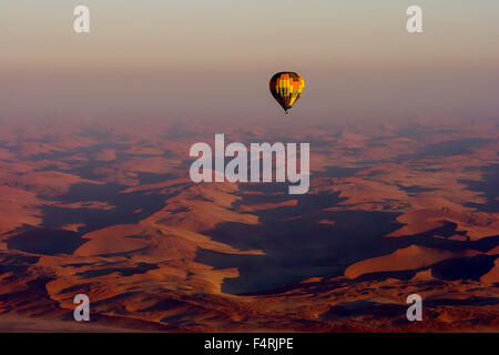 Atemberaubende Aussicht. Heißluftballon fliegen über dem roten Sanddünen Namibias. Stockfoto