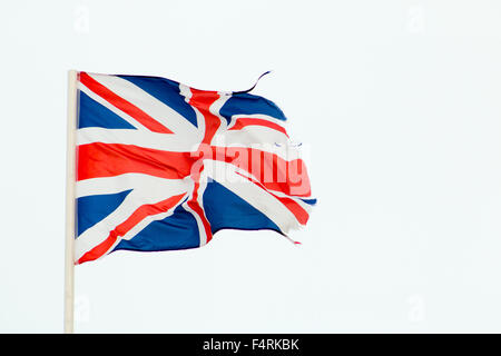 Union Jack auf eine Fahnenstange flattert. Grauen Himmel im Hintergrund. Stockfoto