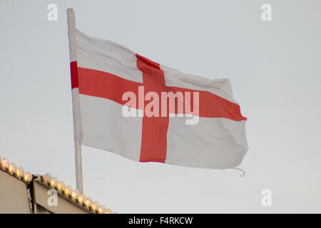 Flagge von England (St.-Georgs Kreuz) auf eine Fahnenstange flattert. Grauen Himmel. Stockfoto