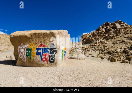 Ein großer tibetean mani Stein mit dem Mantra Om Mani Padme Hum farbenfroh eingraviert ist auf einem Hügel über dem Tal des Indus Stockfoto