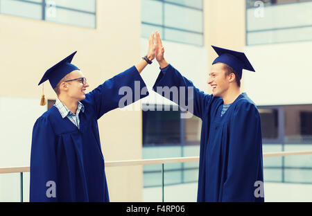 lächelnde Studenten in mortarboards Stockfoto