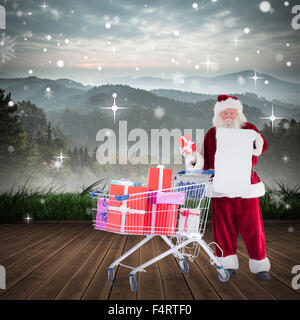 Zusammengesetztes Bild von Santa, die Geschenke aus dem Warenkorb zu liefern Stockfoto