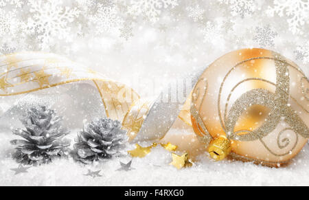 Elegante Weihnachtsarrangement mit eine schöne goldene Kugel, schöne Bänder, silbernen Kegel, viel Schnee und ornamentalen große snowfl Stockfoto