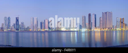 Nacht Skyline Panorama Blick auf moderne Apartment-Hochhäuser entlang der Corniche in Sharjah, Vereinigte Arabische Emirate Stockfoto